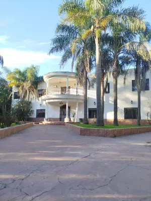 Fachada principal de la casona de Luz del Oasis, rodeada de palmeras